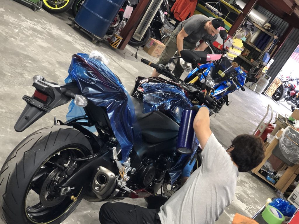 A Suzuki GSX-S being wrapped in protective blue film  in preparation for export