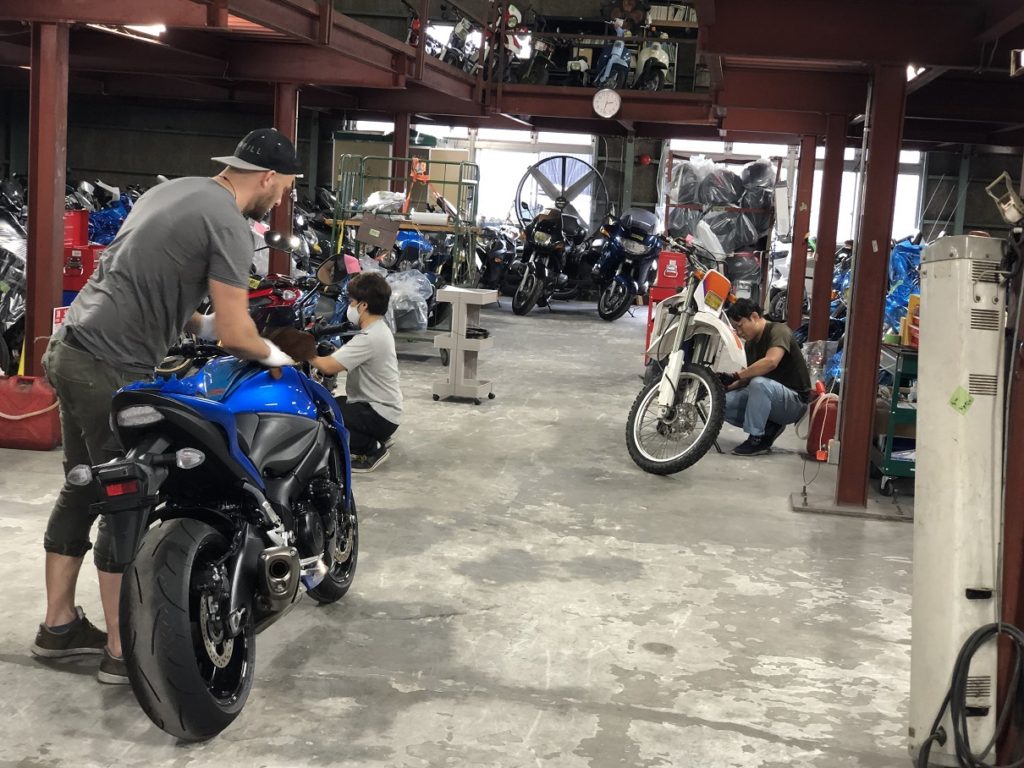 Roy Moving a Motorcycle into the warehouse for inspection